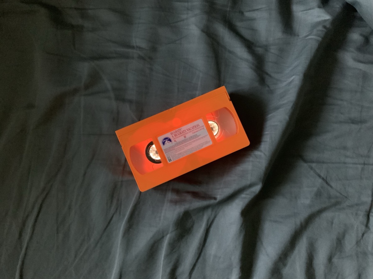Orange VHS cassette on dark fabric